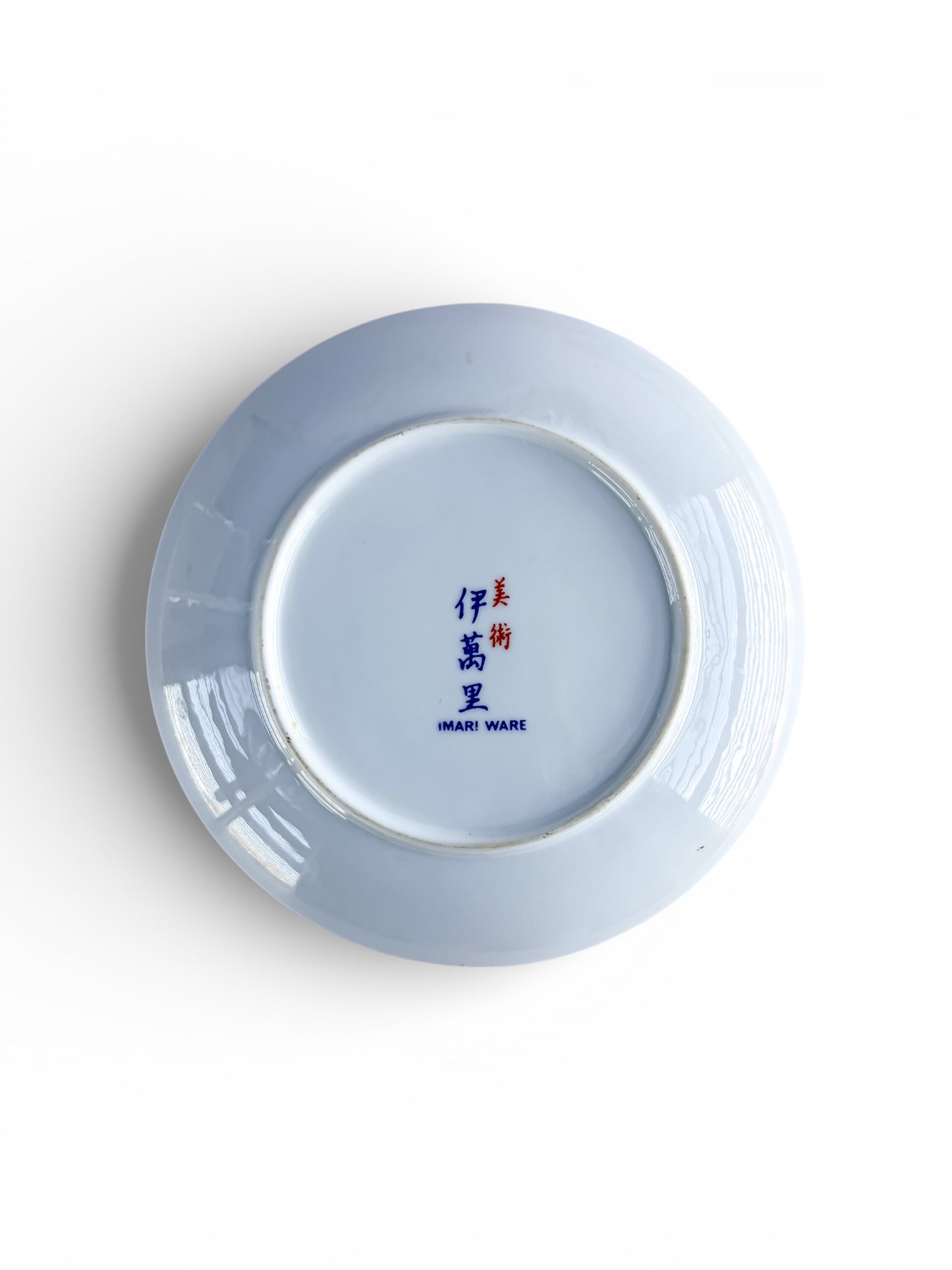 Bottom of ceramic plate with Imari Ware blue and red mark on white porcelain