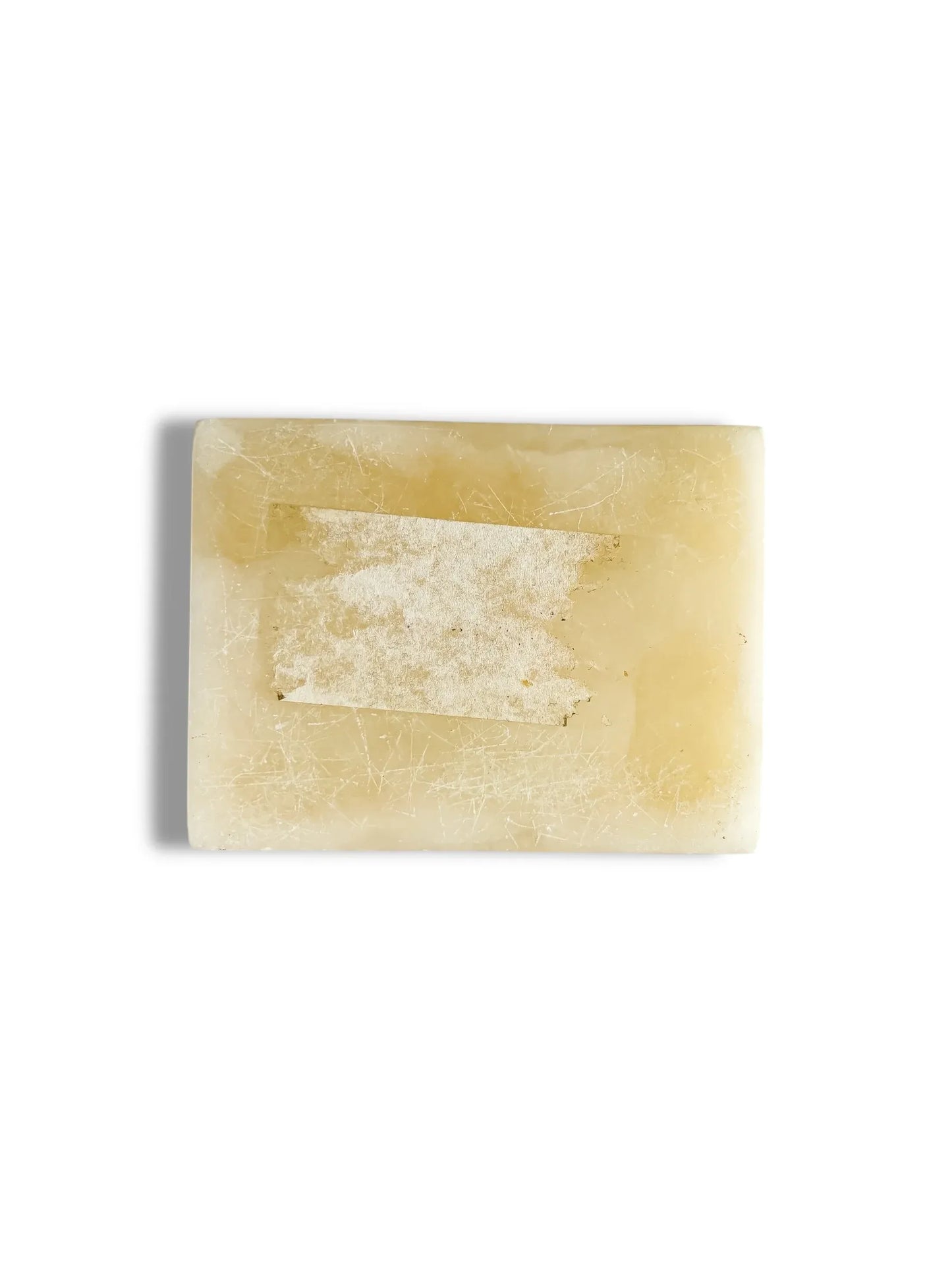 rectangular beige soap bar with worn label and surface scratches on white background