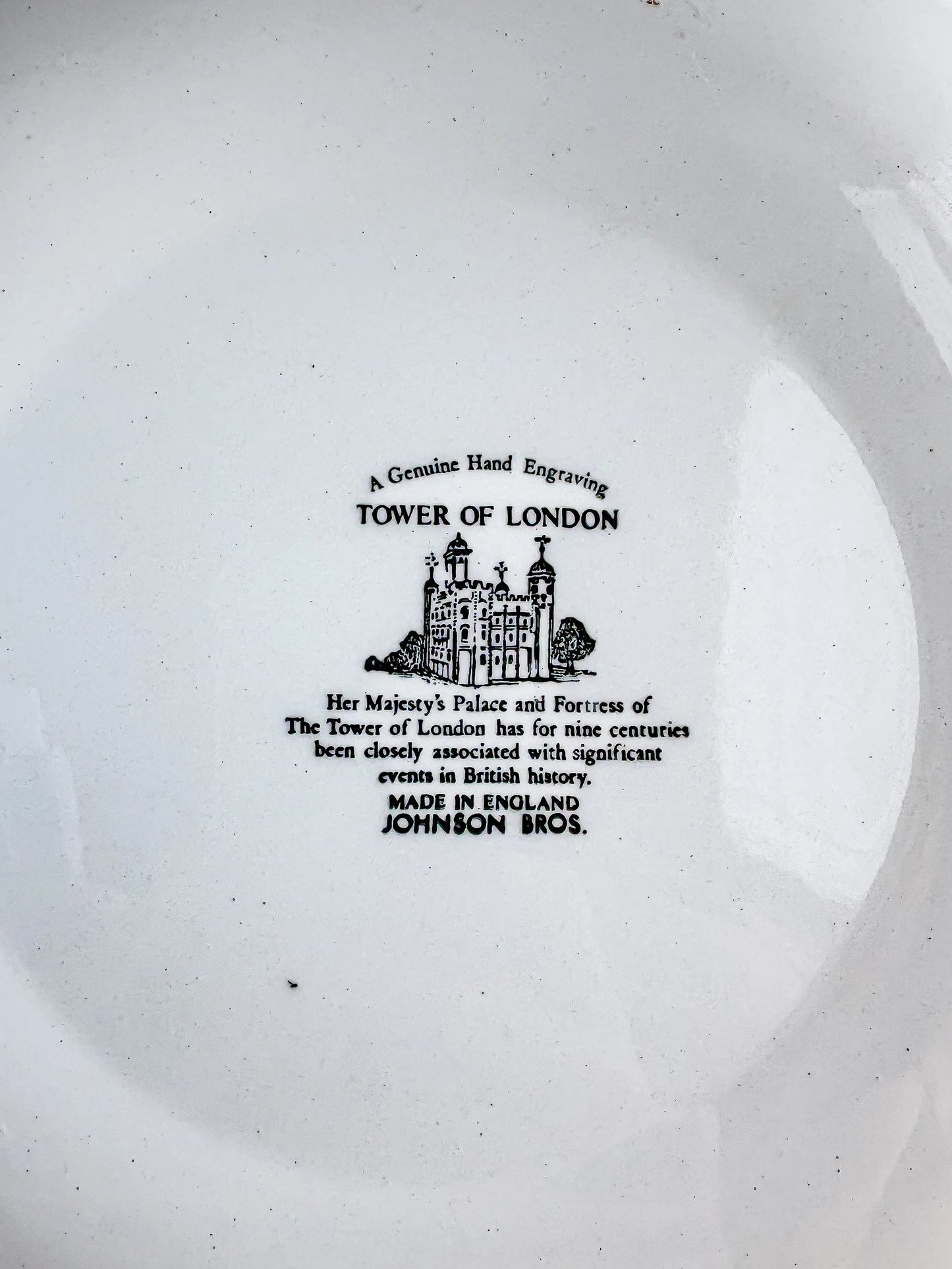 Close-up of the historical text on the back of a vintage Johnson Bros plate describing the nine-century history of the Tower of London.