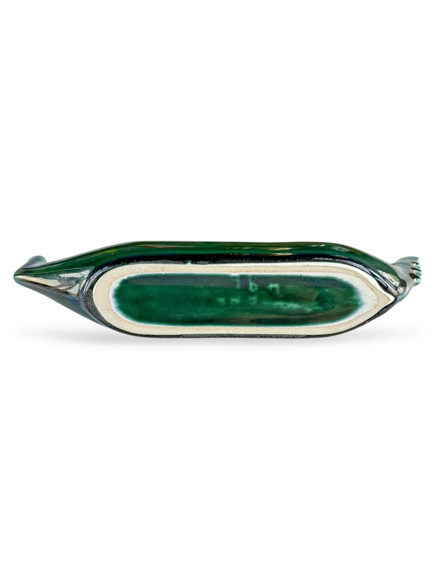 Green ceramic boat-shaped dish with white and dark green glazed interior on white background