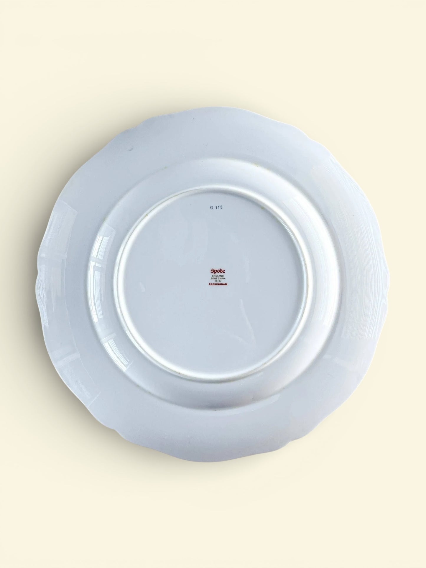 Back view of a white Spode bone china porcelain plate with scalloped edges and manufacturer markings