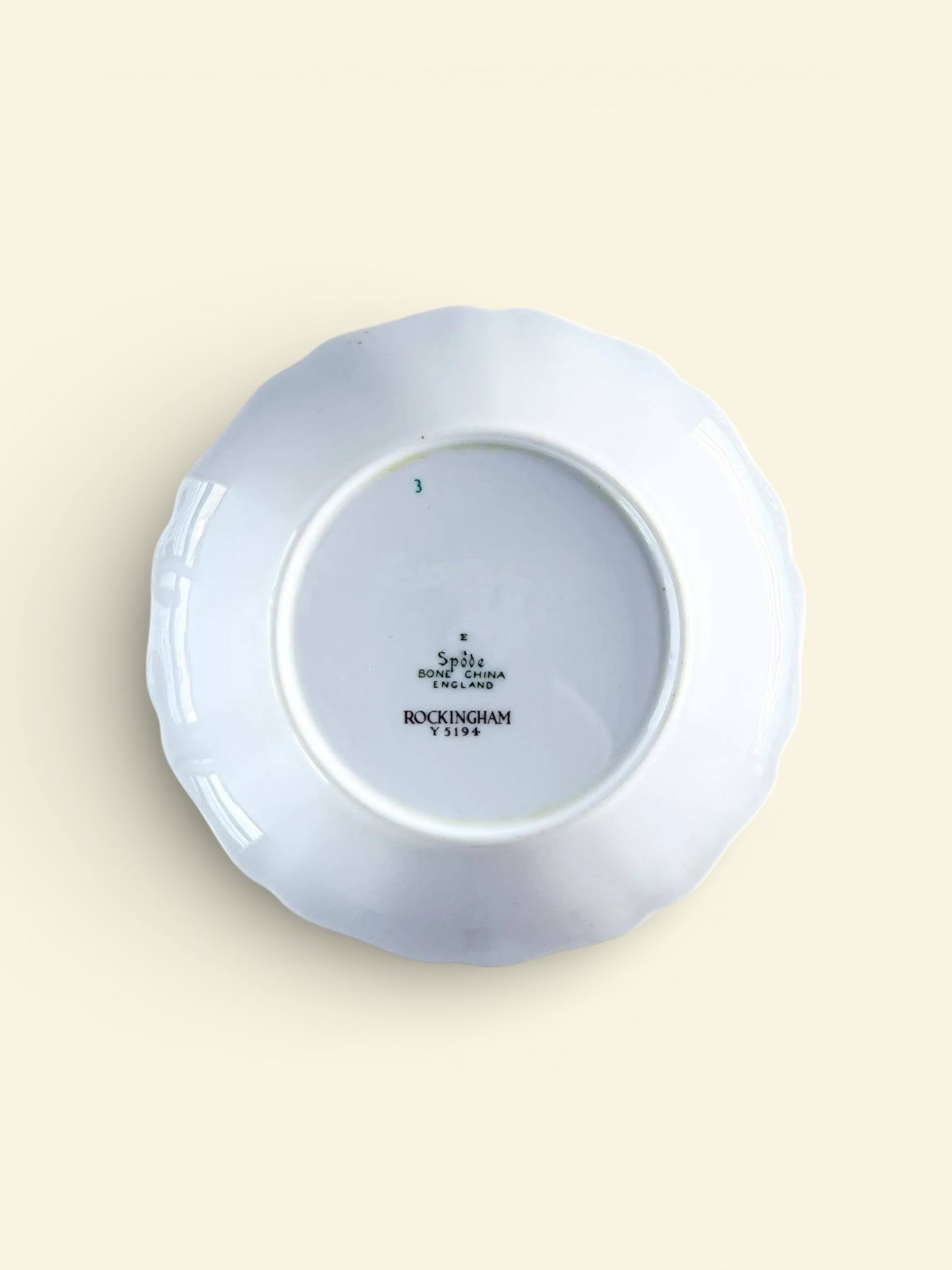 Back of white porcelain plate with scalloped edges, marked Spode bone china England Rockingham Y5194