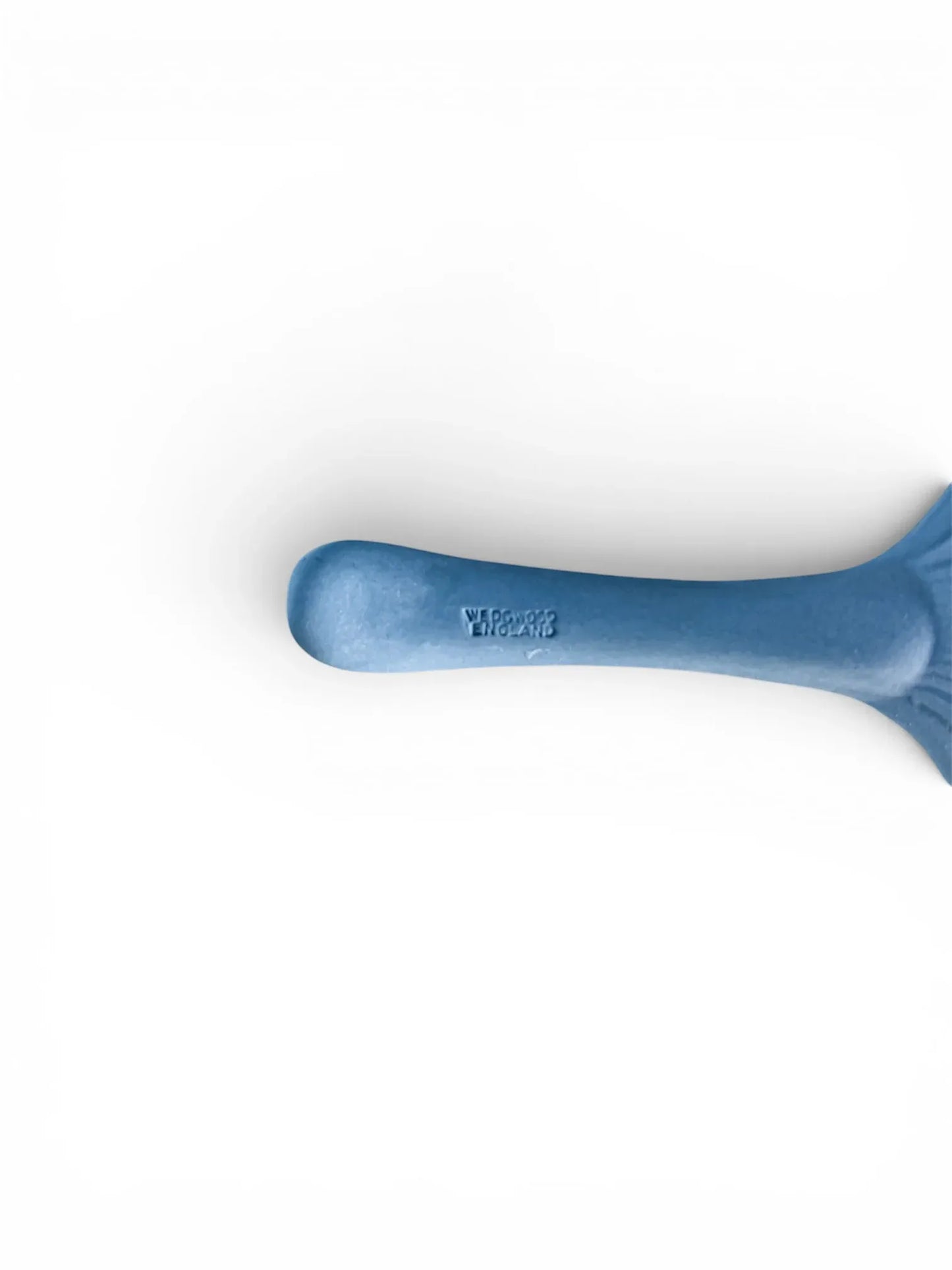 A close-up, high-detail shot of the handle's reverse side on a pale blue Wedgwood Jasperware spoon, clearly displaying the impressed "WEDGWOOD ENGLAND" maker's mark.