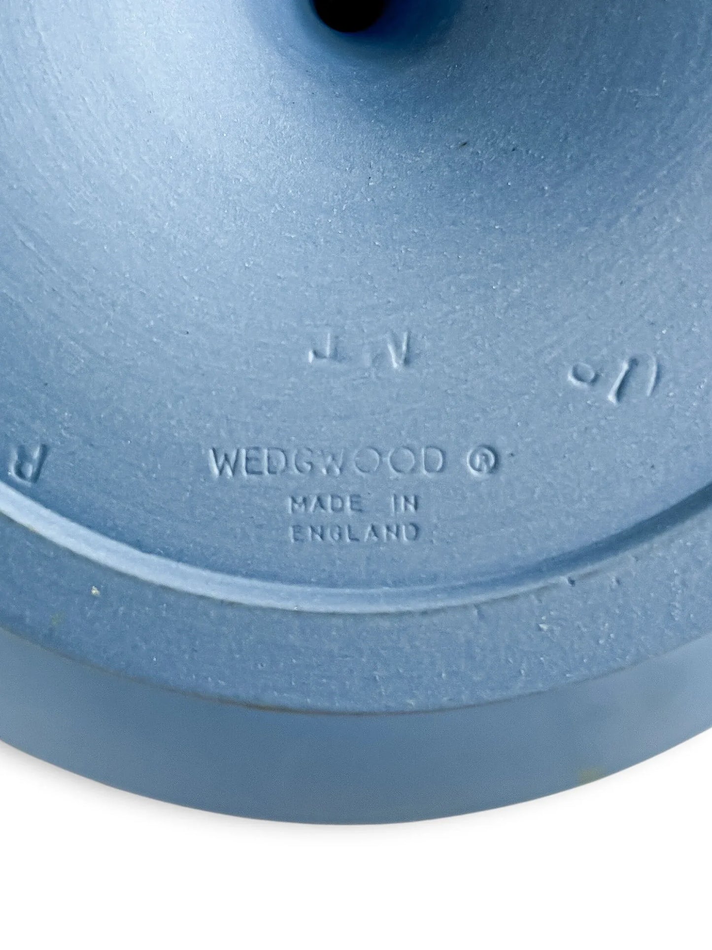 A high-detail close-up of the impressed markings on the base of the pale blue Jasperware compote. The text clearly displays "WEDGWOOD ® MADE IN ENGLAND," along with the potter's batch marks.