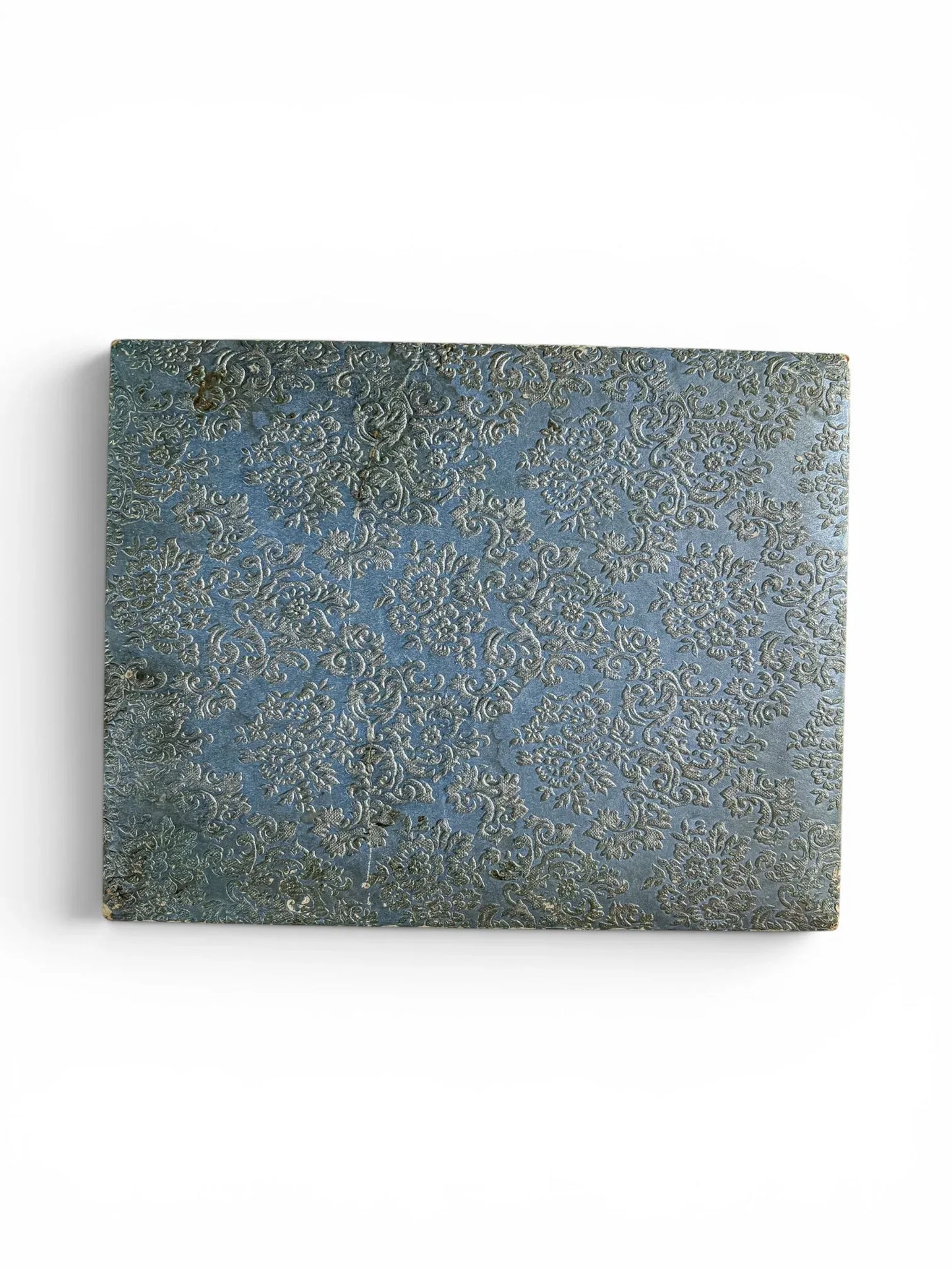 Top-down view of the rectangular vintage cutlery presentation box, showcasing a textured, deeply embossed floral damask pattern in mid-blue.
