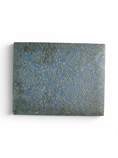 Top-down view of the rectangular vintage cutlery presentation box, showcasing a textured, deeply embossed floral damask pattern in mid-blue.