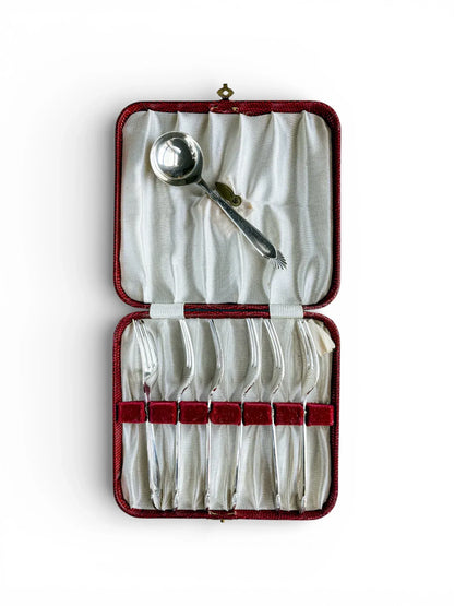 Vintage silver dessert forks and sugar spoon set in red presentation case on white background