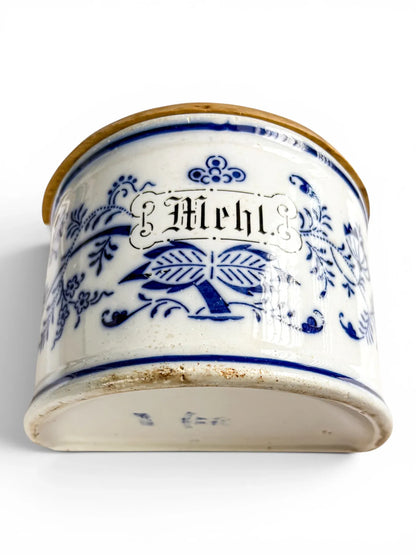 Low-angle front view of the antique German ceramic flour box, highlighting the Mehl Gothic lettering and the unglazed, rustic bottom rim against a white background.