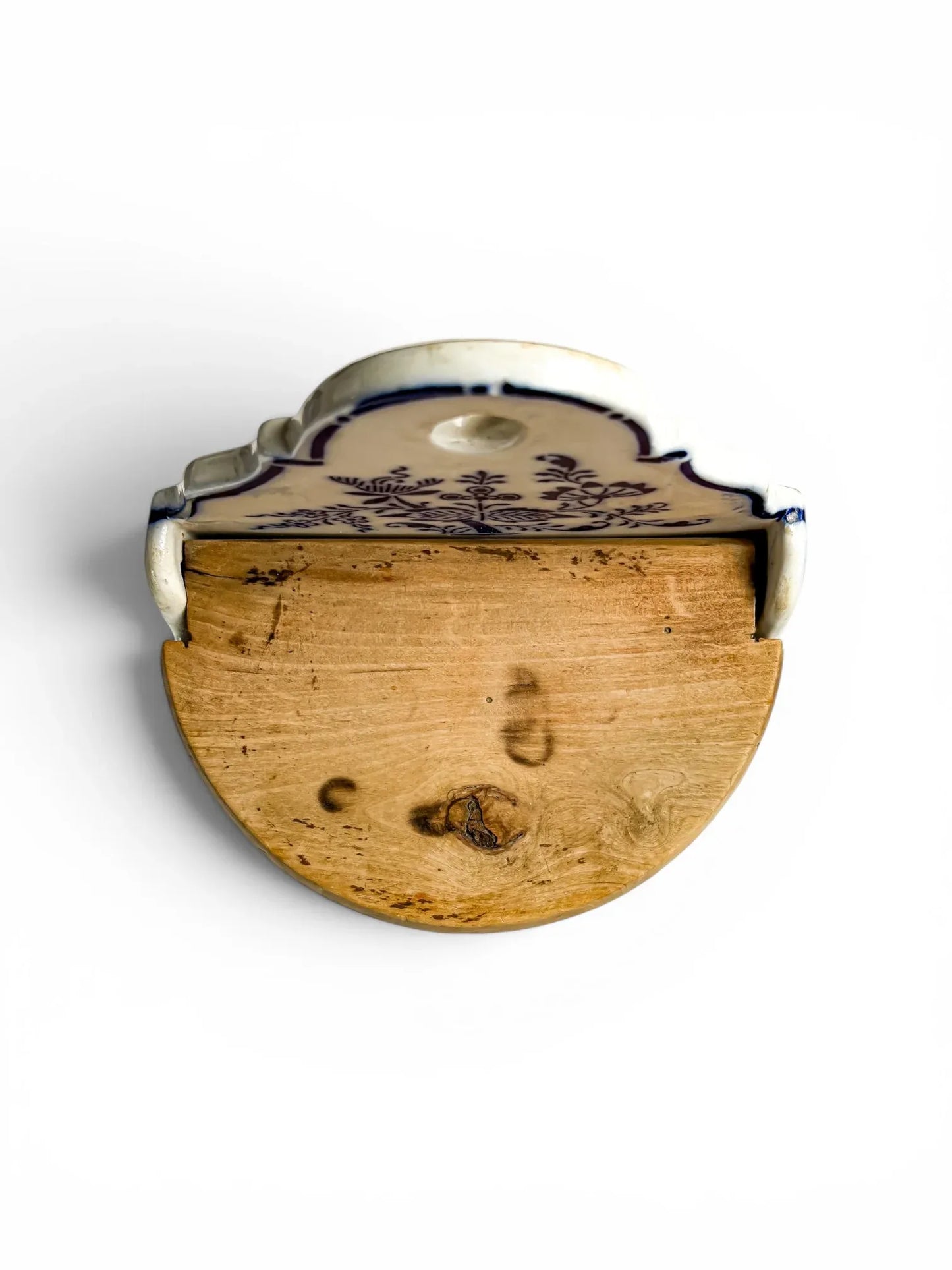 Top-down overhead view of the closed wooden lid of the antique German stoneware flour box, showcasing its semi-circular shape, prominent natural wood knot, and rustic grain.