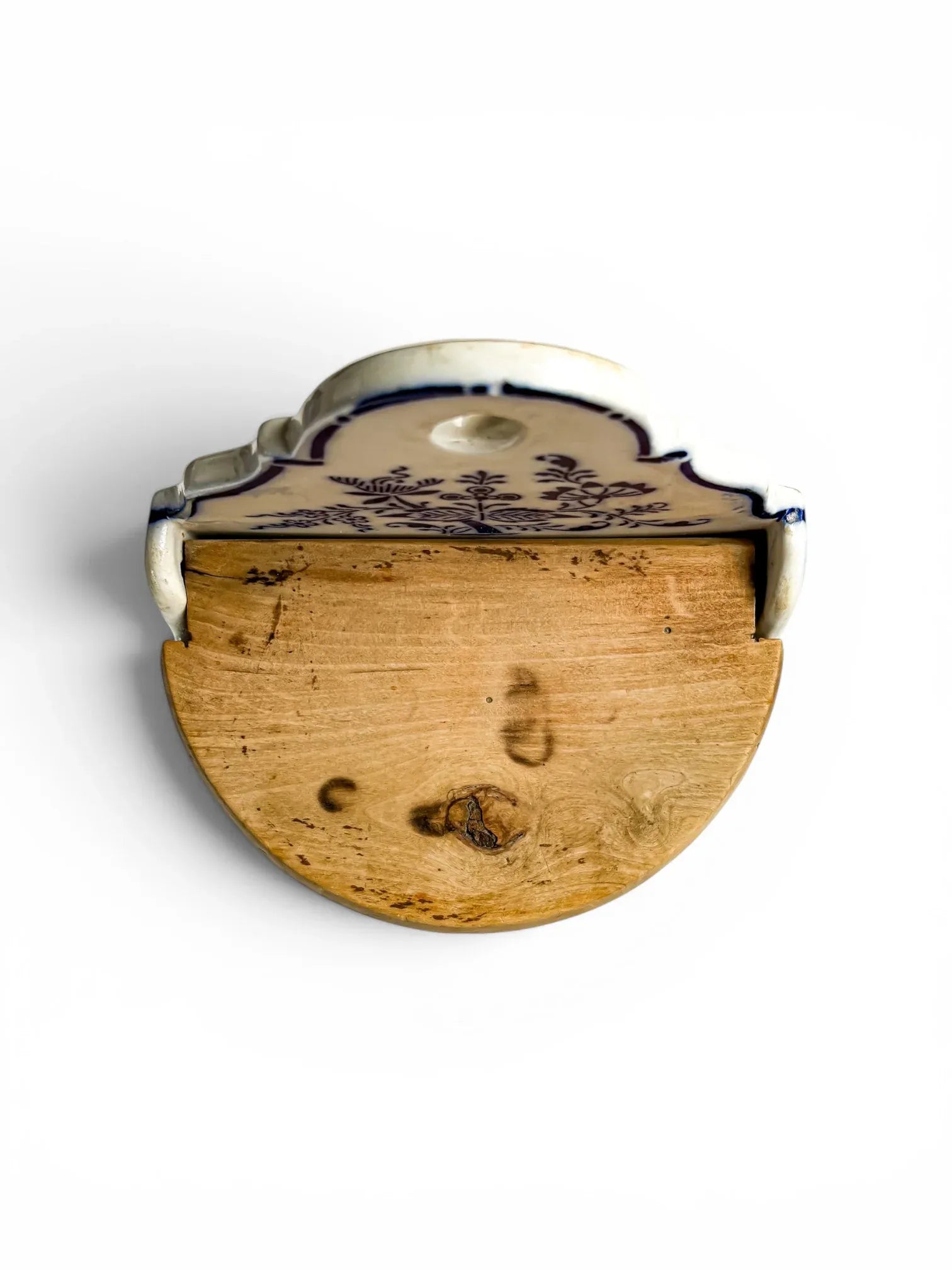 Top-down overhead view of the closed wooden lid of the antique German stoneware flour box, showcasing its semi-circular shape, prominent natural wood knot, and rustic grain.