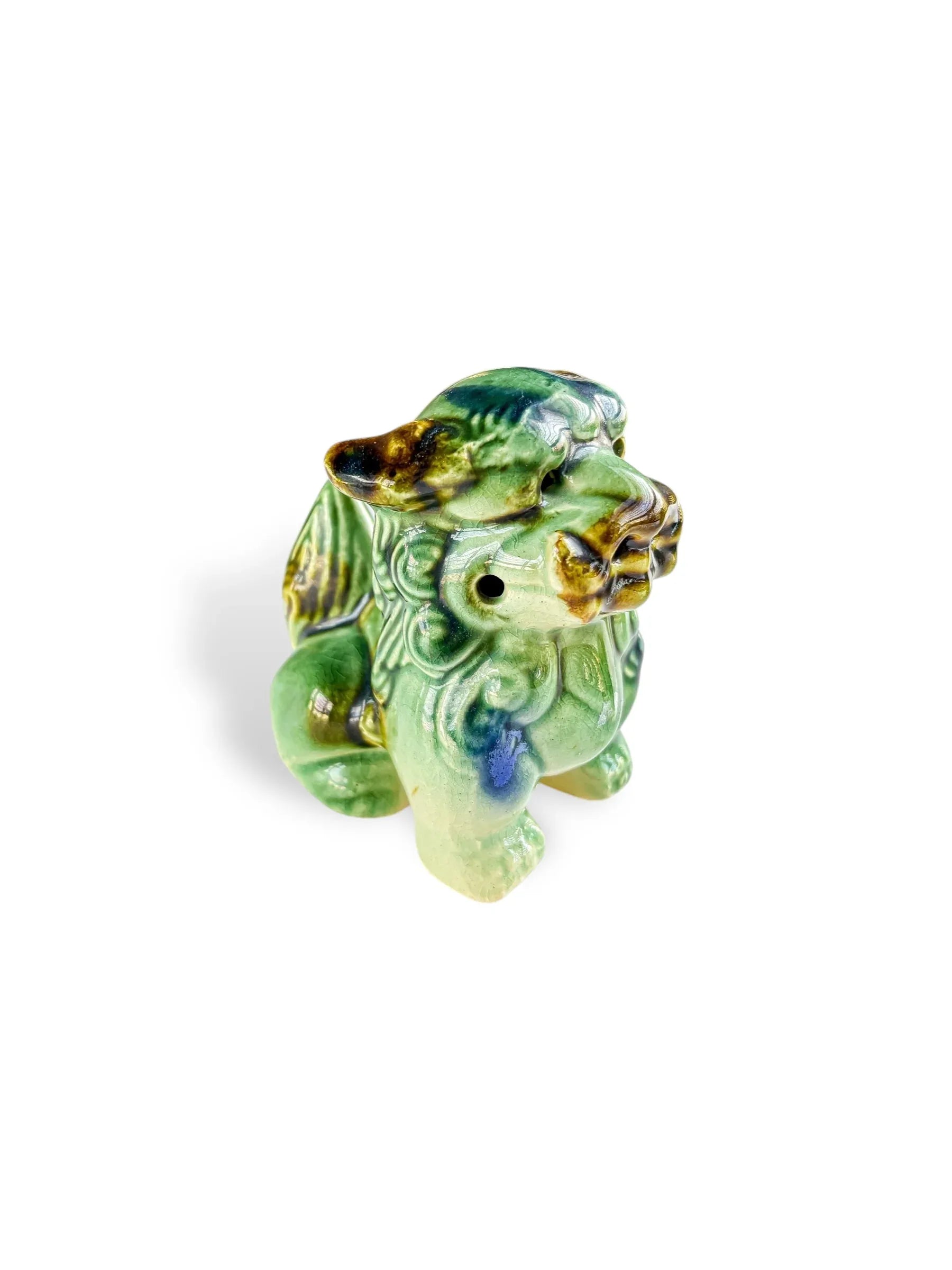 Glossy green ceramic figurine of a mythical foo dog with gold and blue accents on white background