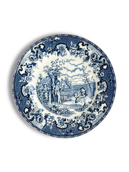 Blue and white vintage ceramic plate with floral border and countryside scene with children playing