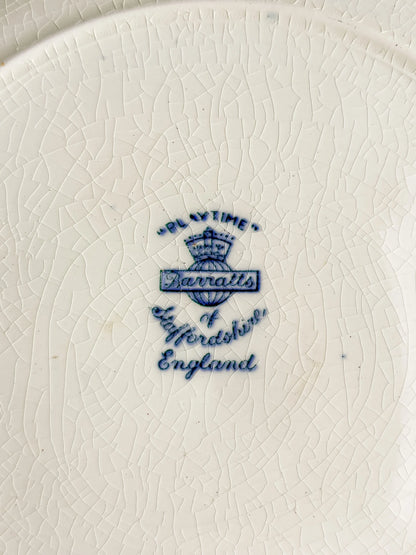 Close-up of vintage Barratts Staffordshire England mark on cracked white ceramic plate