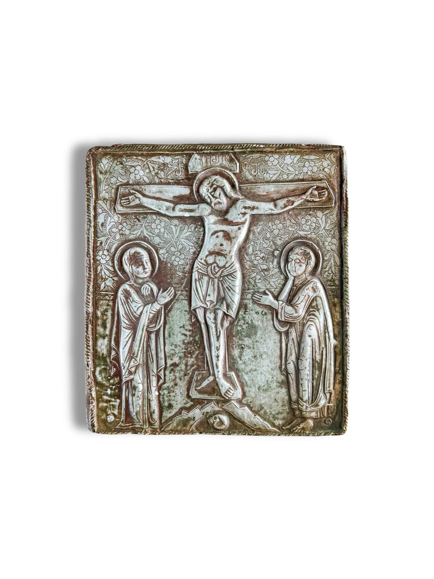 Antique silver religious icon with embossed crucifixion scene and ornate floral details