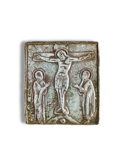 Antique silver religious icon with embossed crucifixion scene and ornate floral details