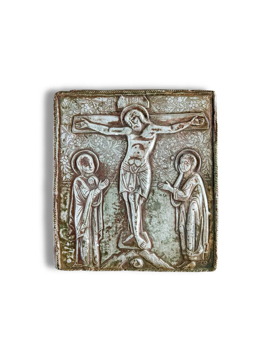 Antique silver religious icon with embossed crucifixion scene and ornate floral details