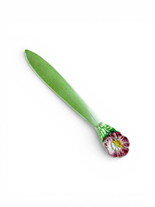 Porcelain green butter spreader with hand-painted pink flower handle on white background