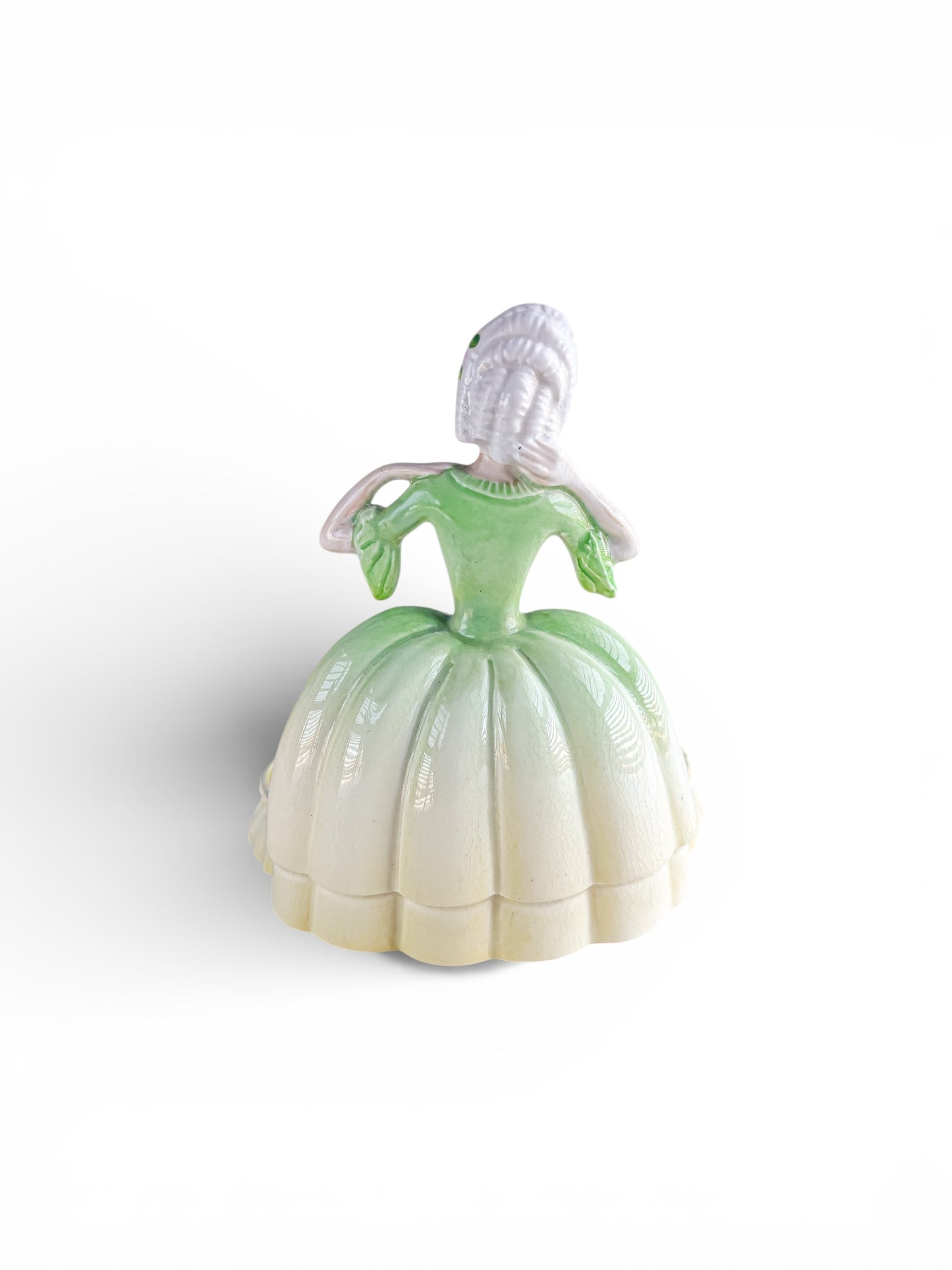 Vintage porcelain figurine of a woman in a green and white Victorian-style dress with detailed hair