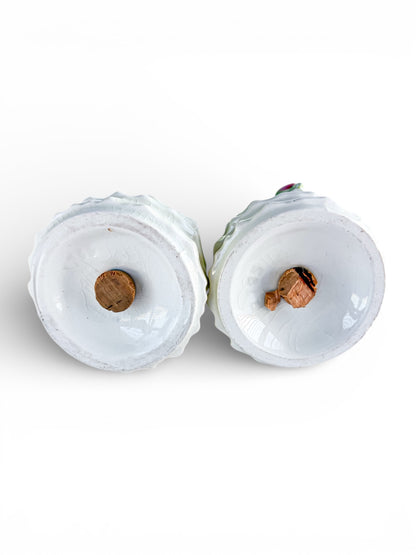 Bottom view of two vintage white porcelain decorative items with cork bases on white background