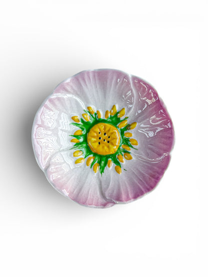 Hand-painted ceramic flower-shaped plate with pink petals and yellow-green center on white background