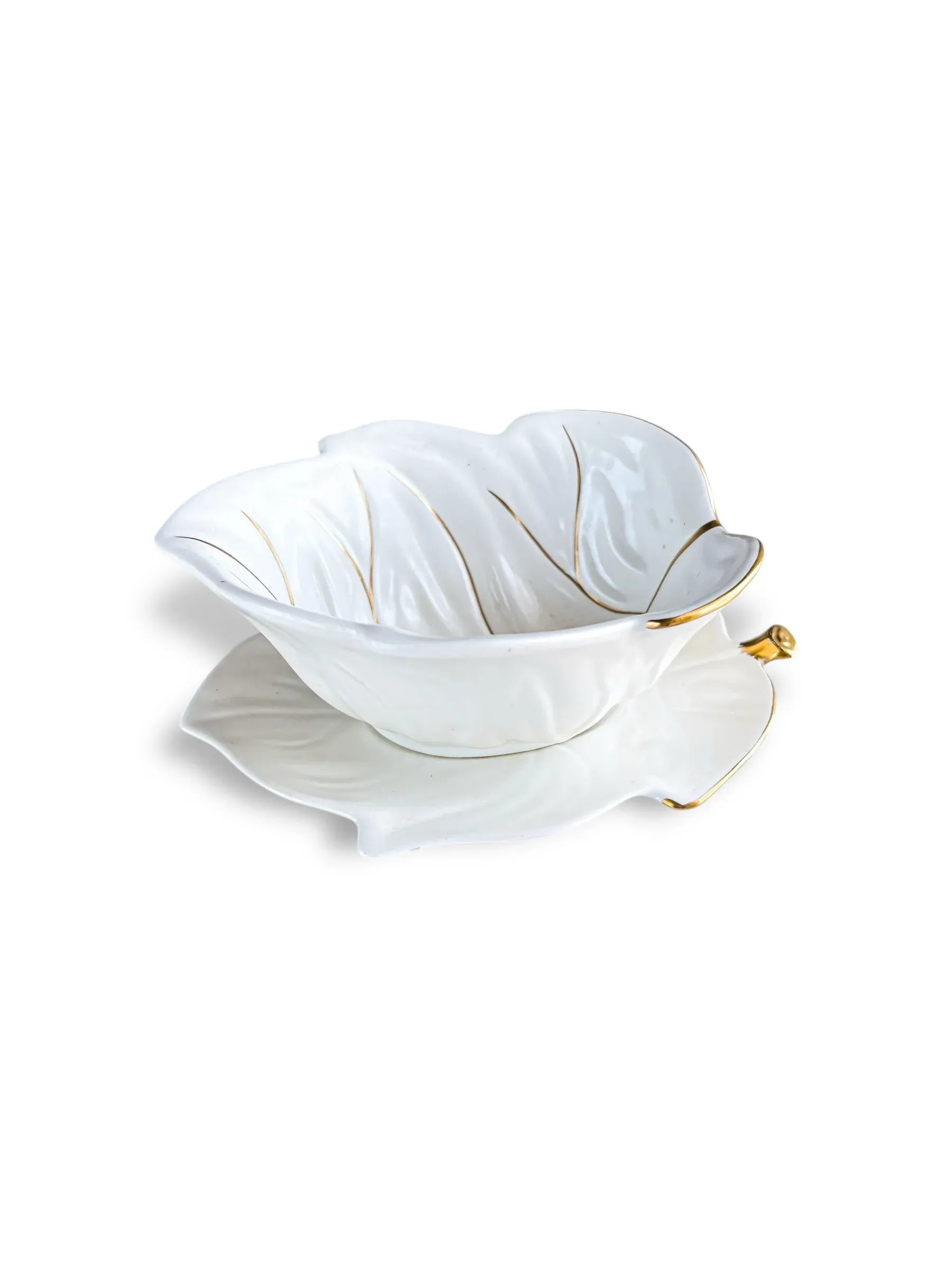 White ceramic leaf-shaped bowl with gold trim and matching plate on white background