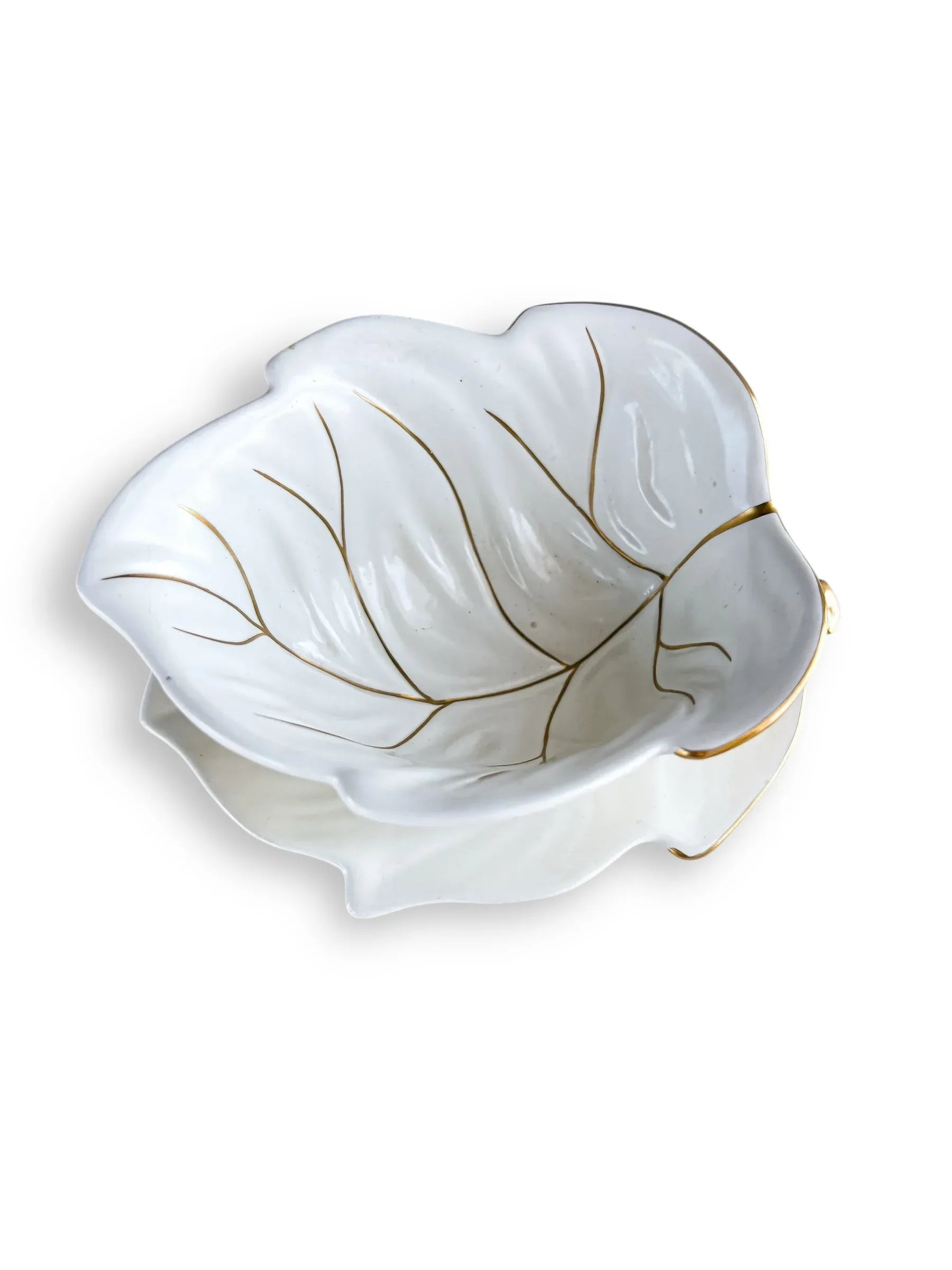 White ceramic leaf-shaped bowl with gold detailing, elegant dish on white background