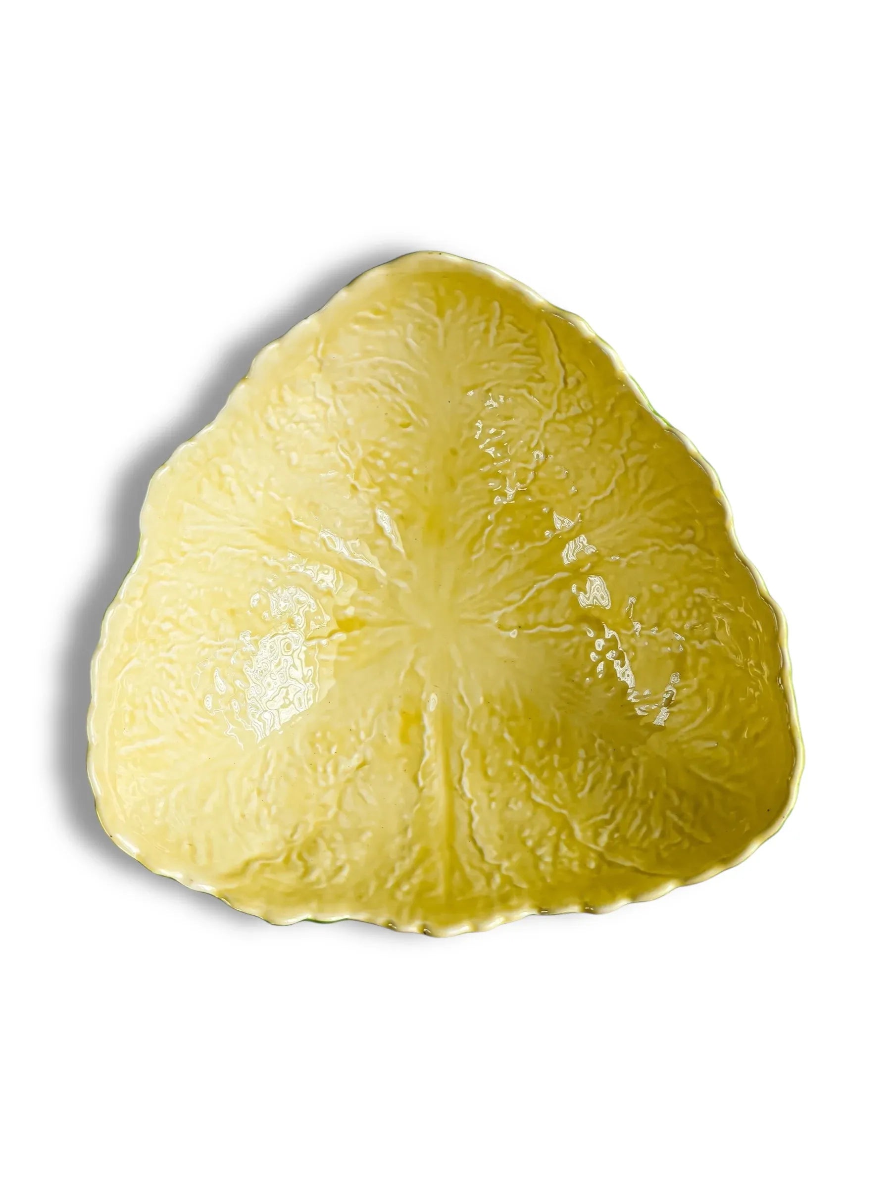 Yellow ceramic leaf-shaped decorative plate with textured vein details on white background