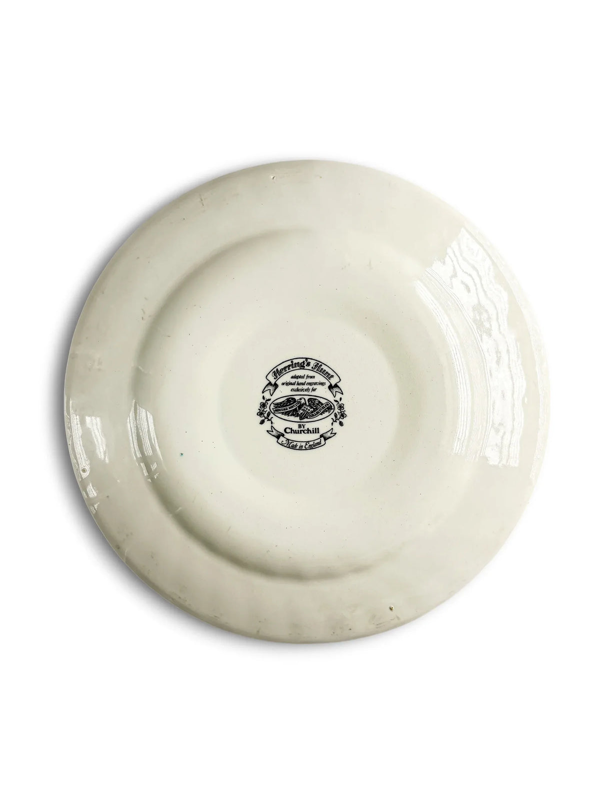 Reverse of the Churchill Herring’s Hunt Breaking Cover plate, showing the glazed cream back, foot ring, light kiln specks and the circular black backstamp in the centre.