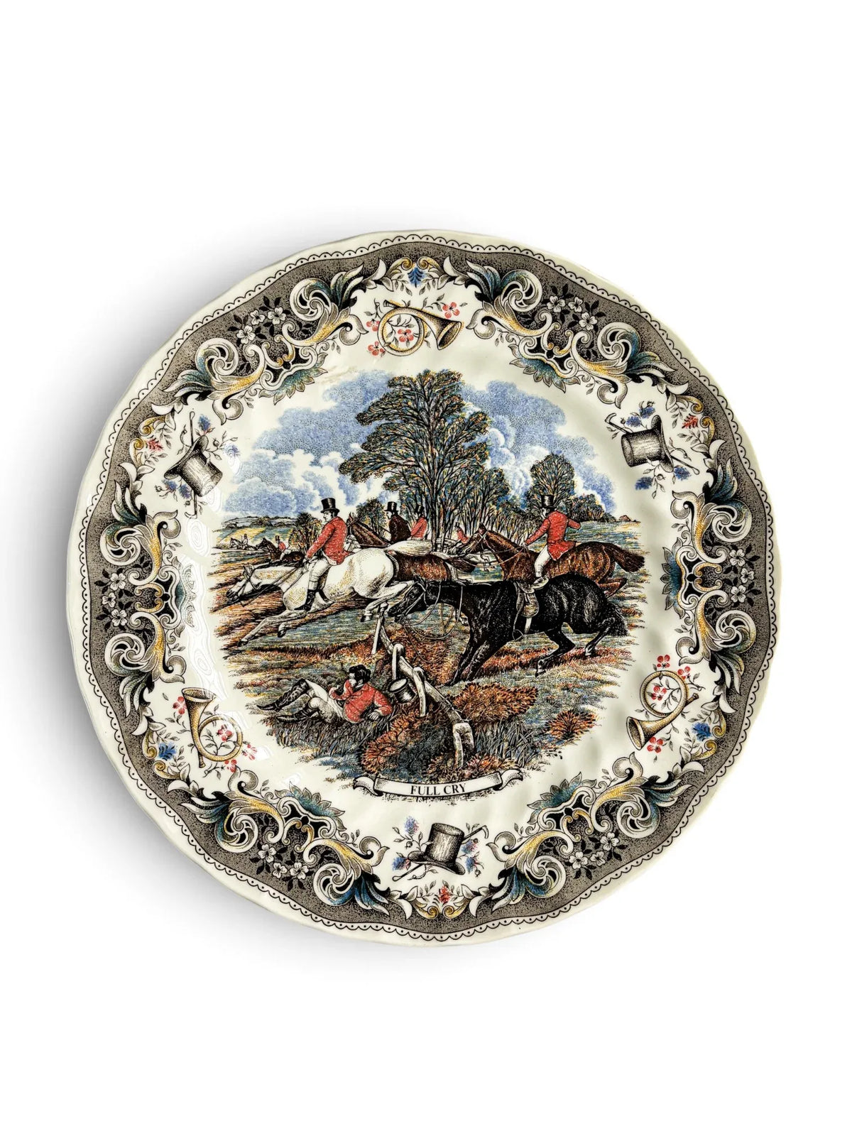 Vintage Churchill Herring’s Hunt dinner plate titled Full Cry, showing a fox-hunting scene with riders in red coats jumping a fence, a fallen huntsman in the foreground, and an ornate grey border of horns, top hats and flowers. Scalloped rim. Photographed from above on a white background.