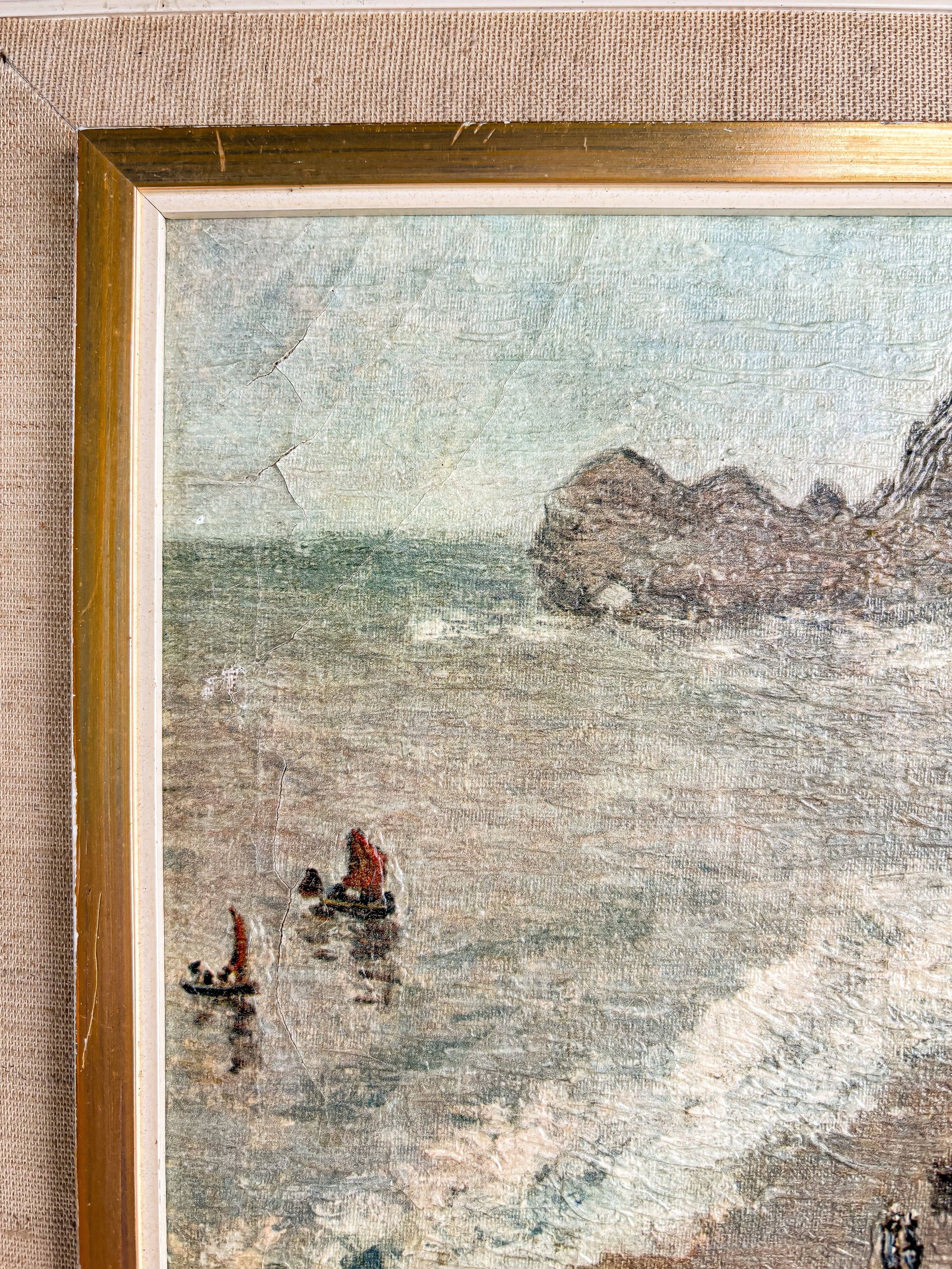 Close-up of framed painting showing two small boats with red sails near a rocky coastline and calm sea