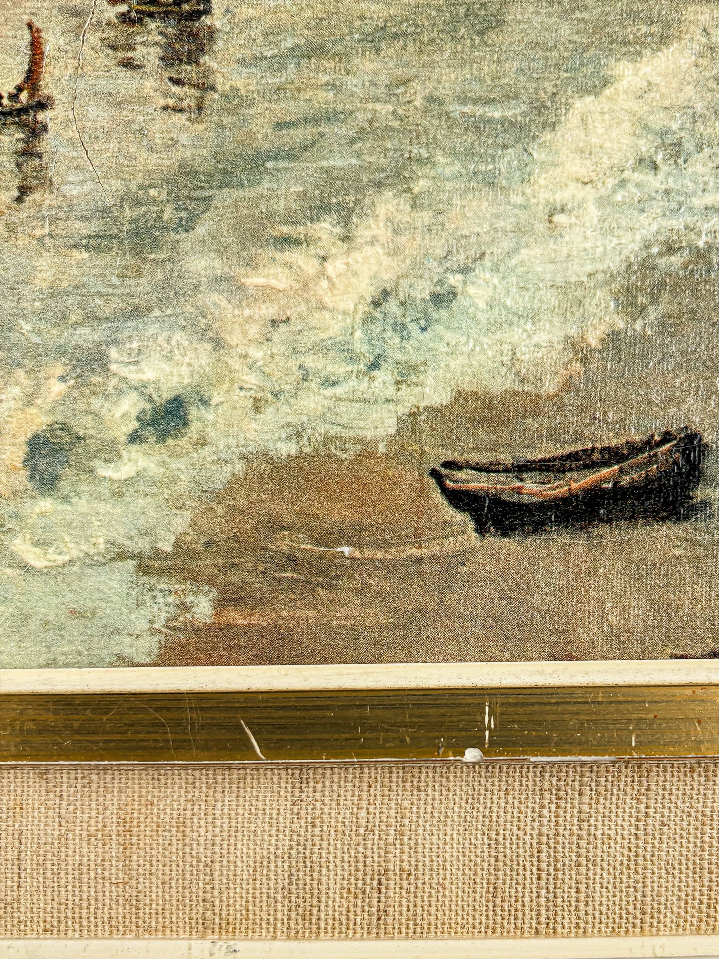 Close-up of framed vintage painting showing a small boat on textured water with muted blues and browns