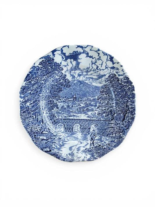 Top-down view of a vintage Crown Ducal Bridge Scenes luncheon plate, 22cm. Featuring a hand-engraved blue and white transferware landscape with an arched stone bridge, fisherman, and village church.