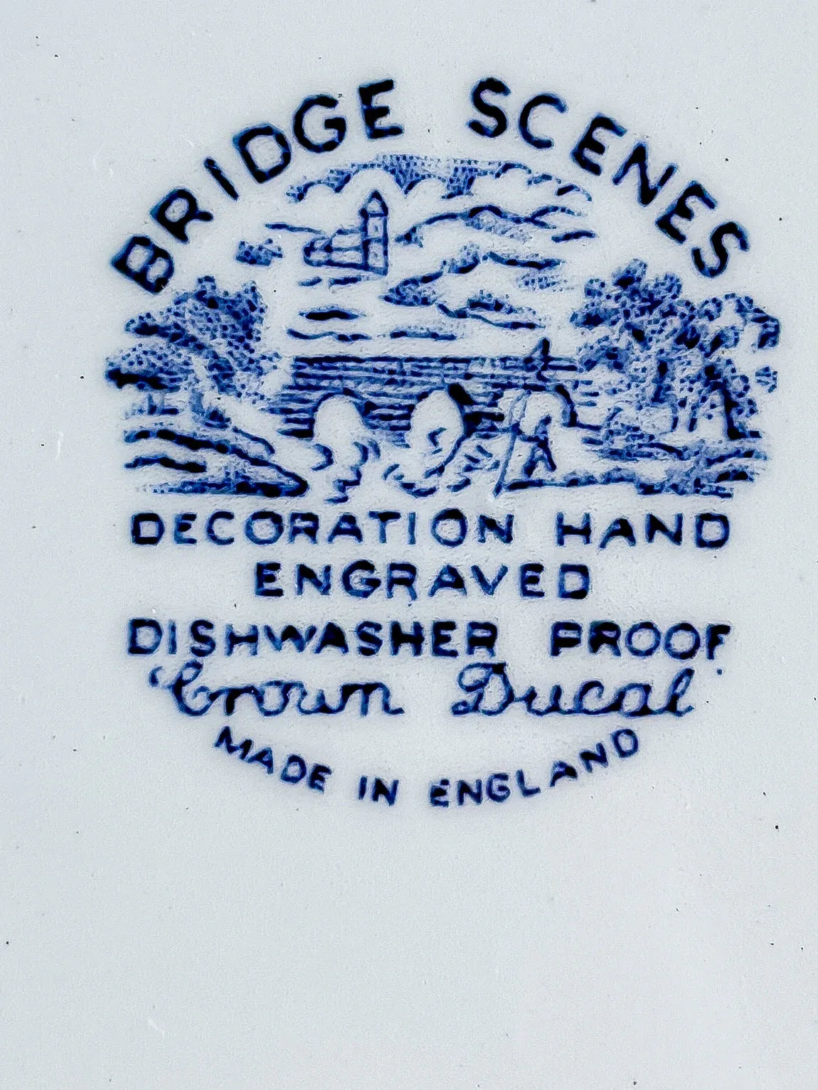 Macro close-up of the Crown Ducal Bridge Scenes backstamp. Detailed blue transfer mark on white ceramic, indicating 1960s-1970s English pottery from A.G. Richardson & Co. Ltd.