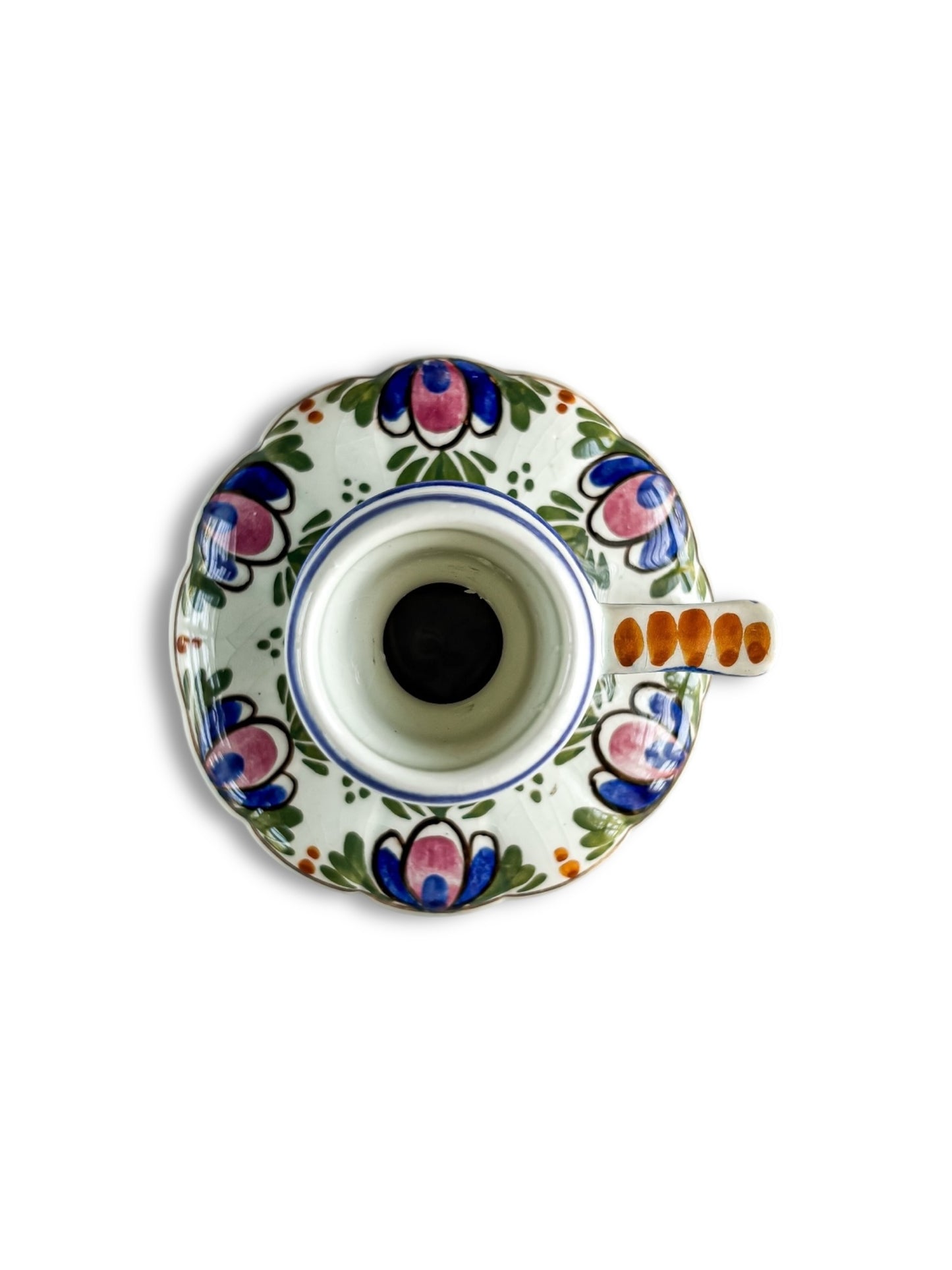 Top view of a vintage porcelain candle holder with floral hand-painted designs in blue, pink, green, and orange