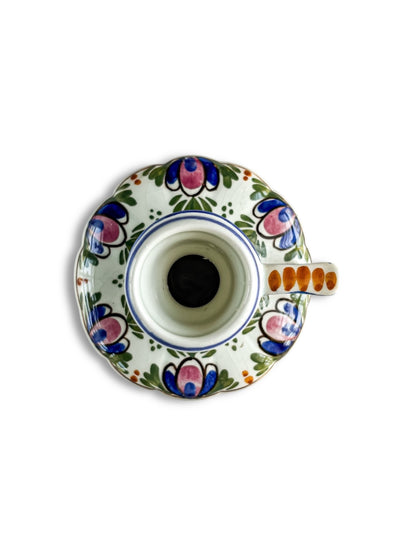 Top view of a vintage porcelain candle holder with floral hand-painted designs in blue, pink, green, and orange