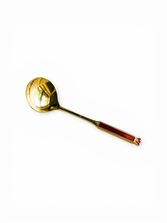 A 24-carat gold-plated Eetrite sugar spoon with a rounded bowl and ruby red handle, isolated on a white background.