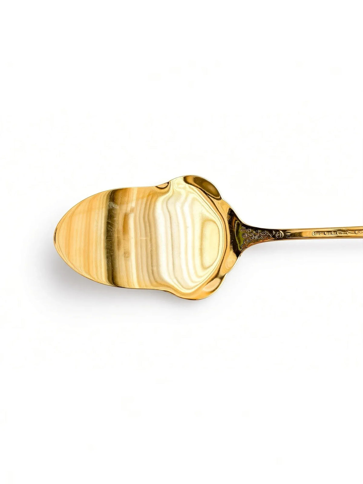 Close-up of the front of the gold plated spoon bowl with bright reflections and floral engraving at the neck