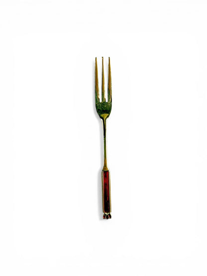 A single Eetrite gold-plated cake fork shown vertically, highlighting the three-tine design and the detailed red enamel handle.