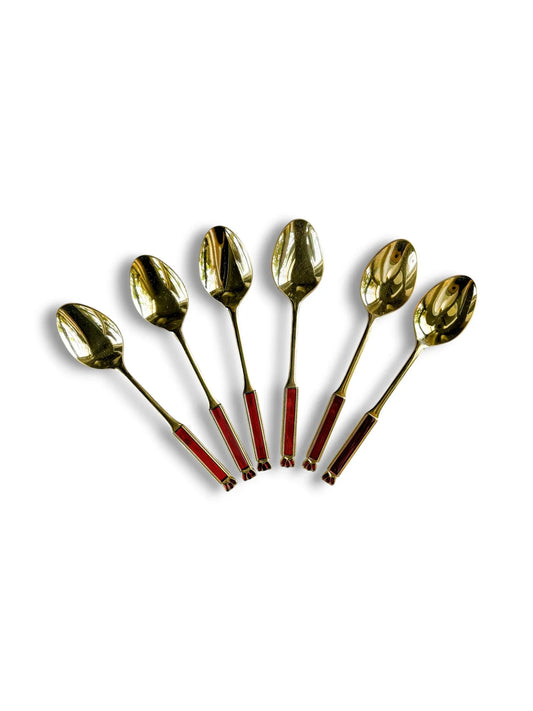 A fan-shaped arrangement of six vintage Eetrite teaspoons with 24-carat gold plating and ruby red enamel handles, displayed on a clean white background.
