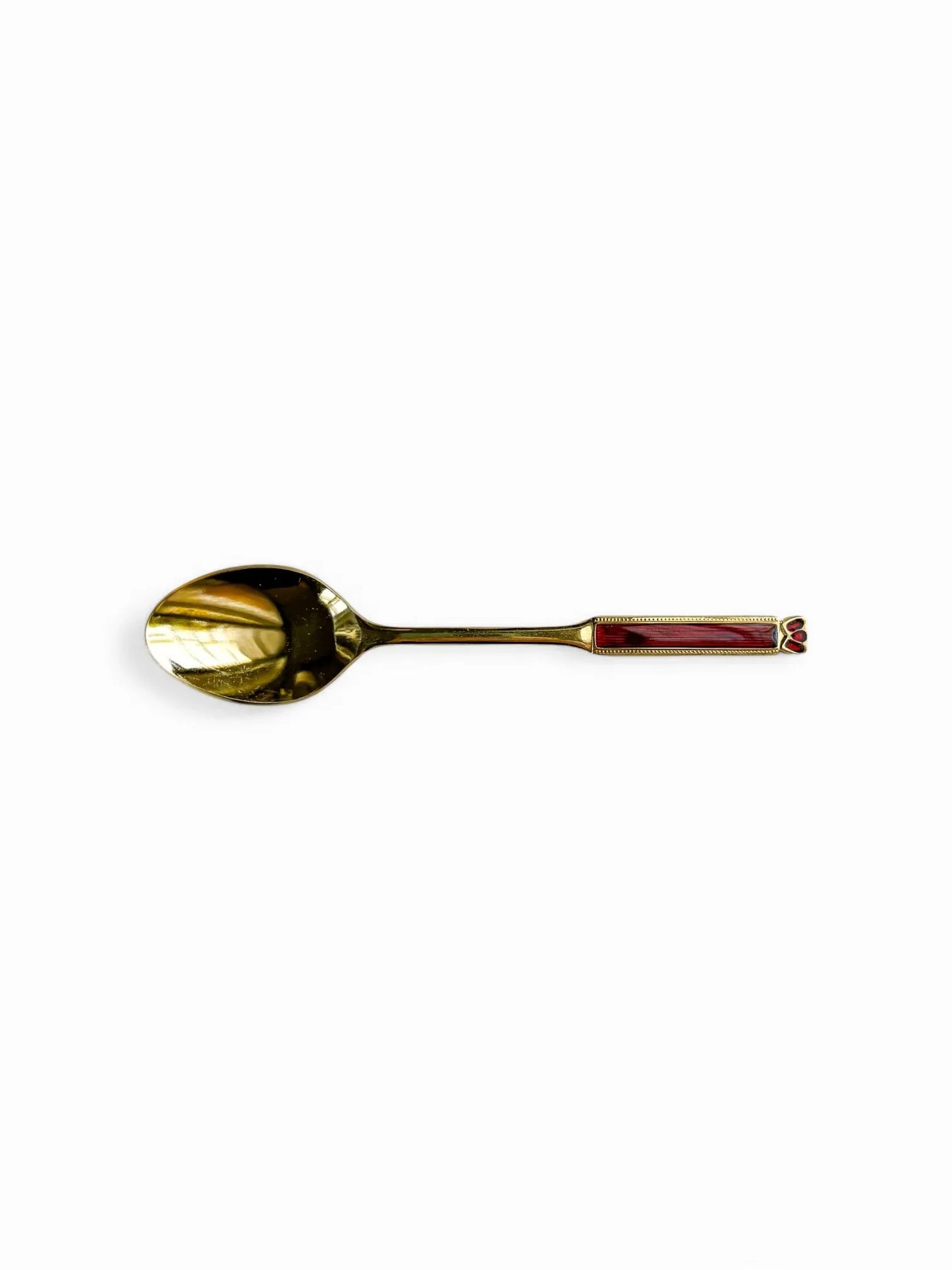 A horizontal studio shot of a 24-carat gold-plated Eetrite teaspoon, highlighting the rectangular ruby red enamel inlay and beaded gilt border on a pure white background.