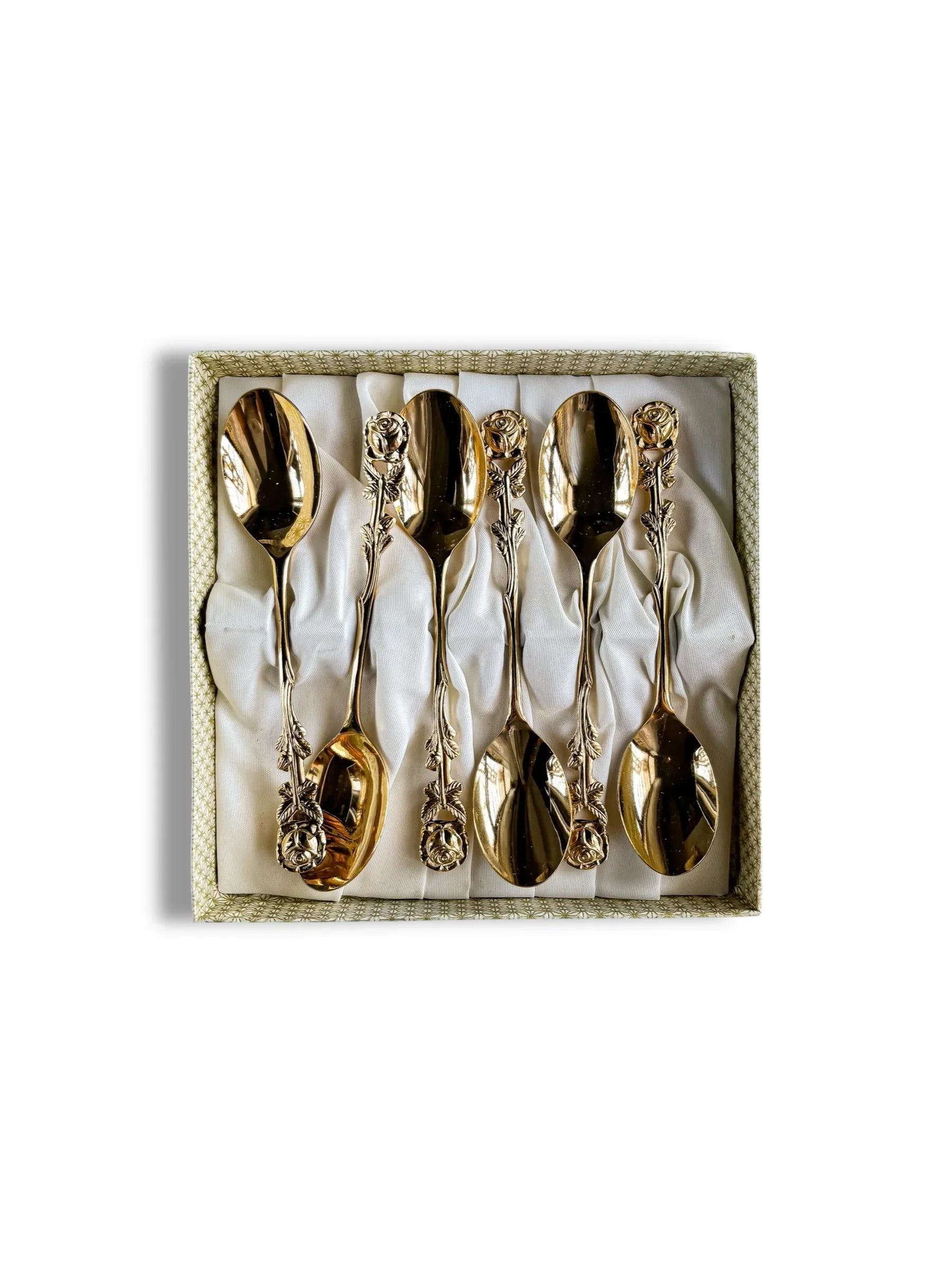 Set of six gold-tone decorative spoons with rose-patterned handles displayed in a lined box