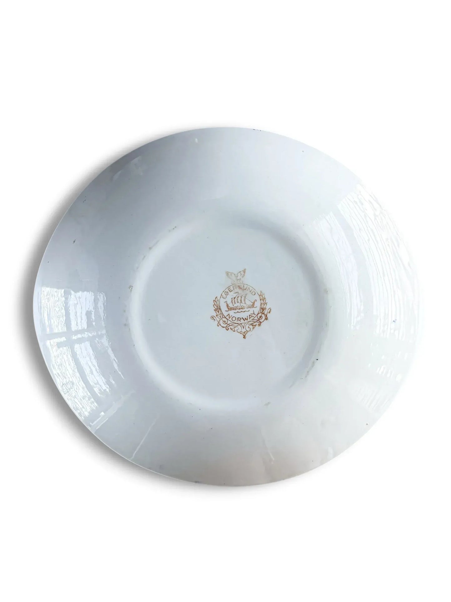 The clean white underside of a vintage Norwegian ironstone serving platter, showing the oval silhouette and the central Egersund Viking ship maker's mark.