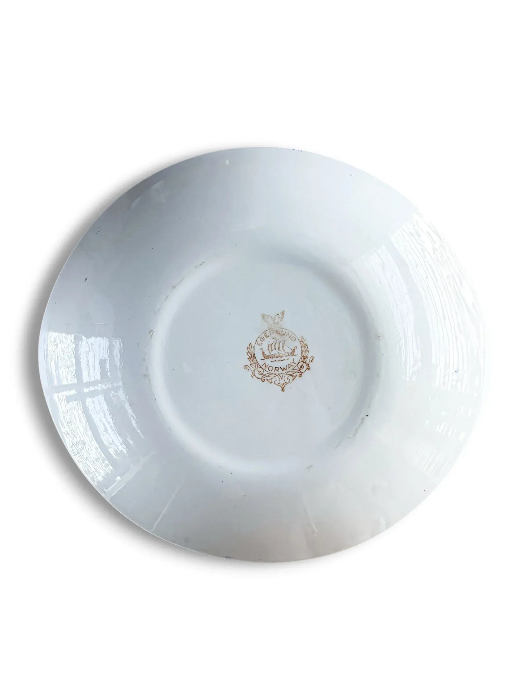 The clean white underside of a vintage Norwegian ironstone serving platter, showing the oval silhouette and the central Egersund Viking ship maker's mark.
