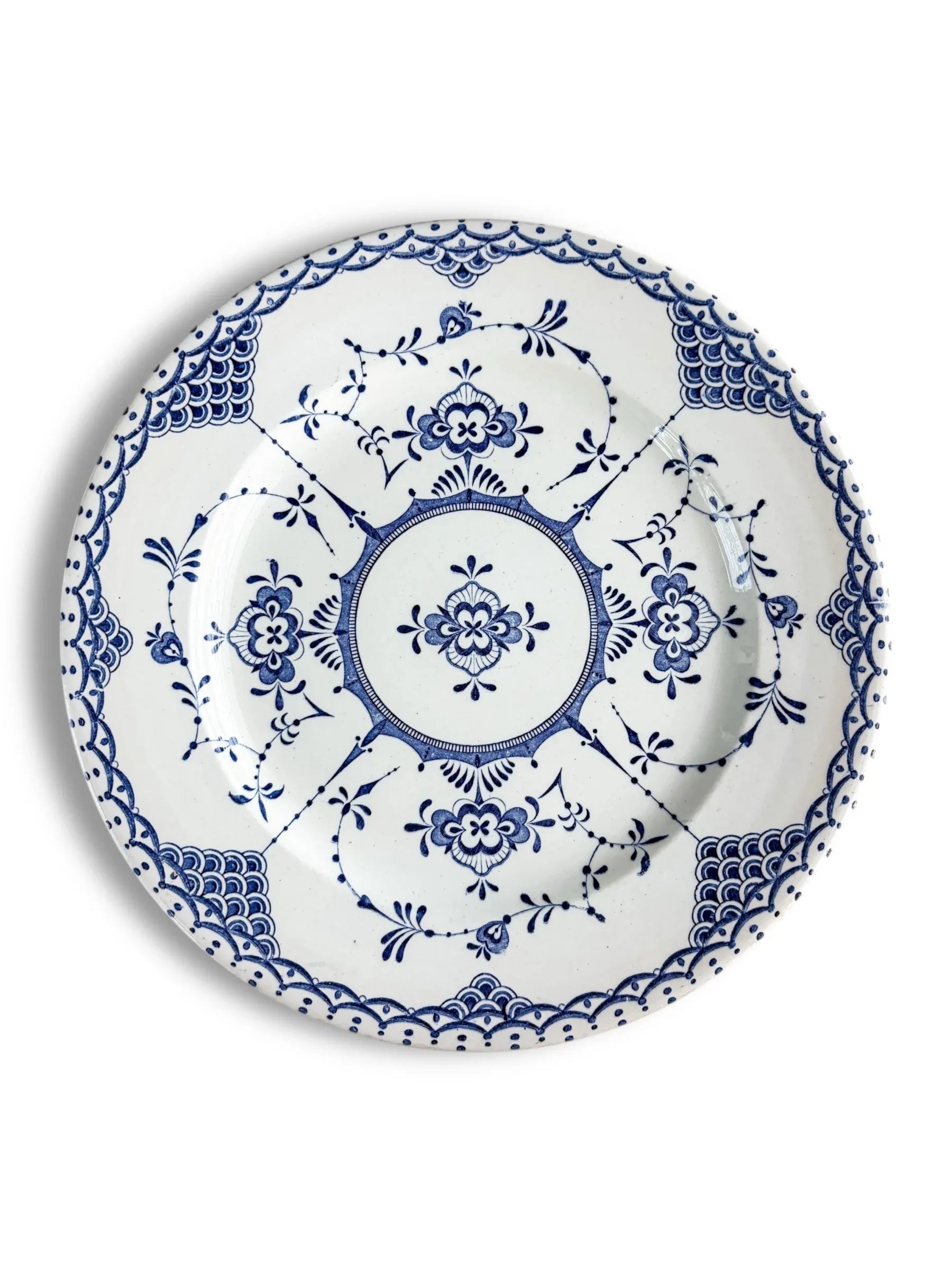 White ceramic plate with intricate blue floral and geometric patterns in vintage style