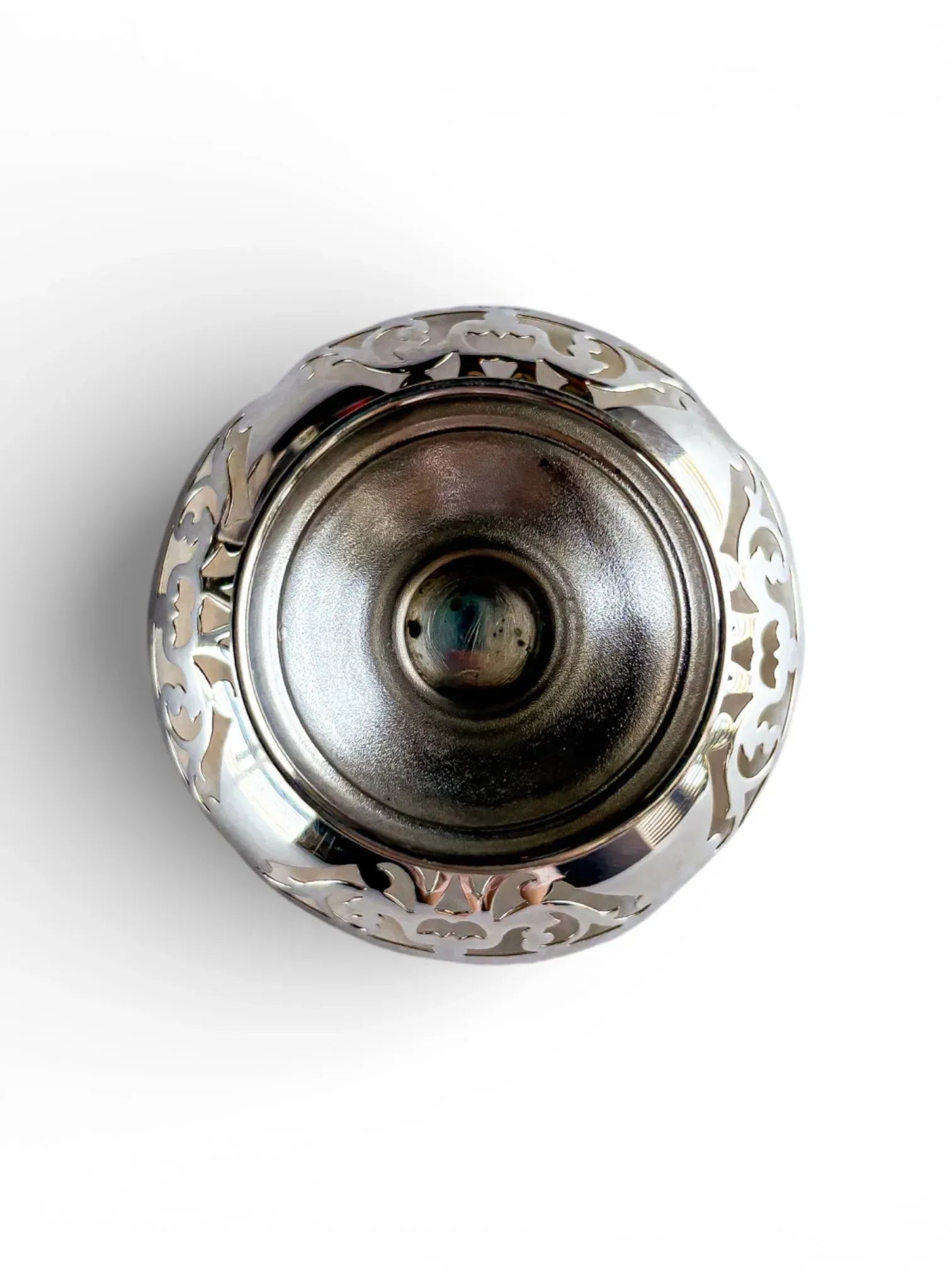 Birds-eye view of a vintage silver bonbon dish highlighting the symmetrical foliate patterns.