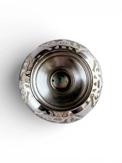 Birds-eye view of a vintage silver bonbon dish highlighting the symmetrical foliate patterns.