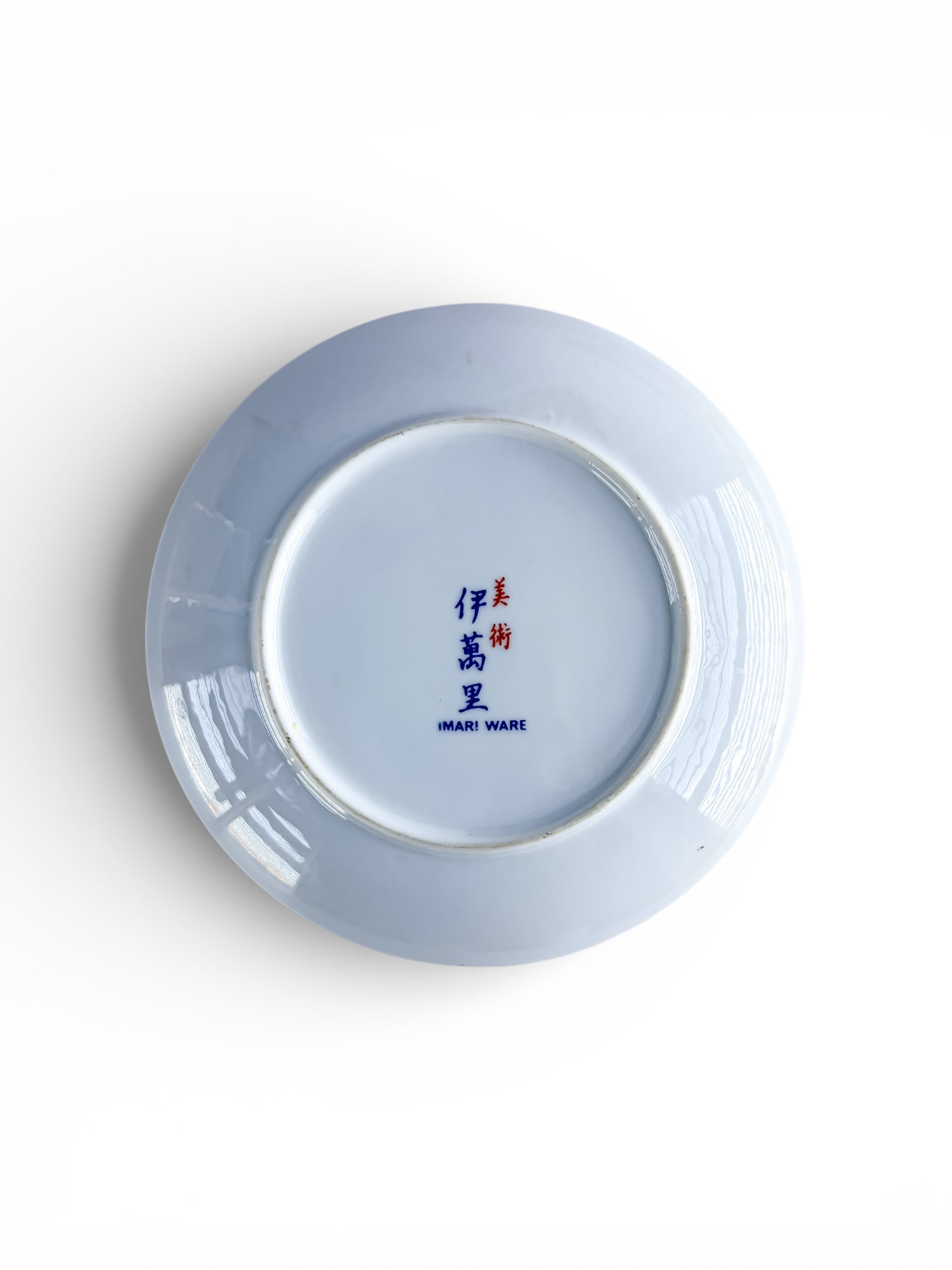 Bottom of ceramic plate with Imari Ware blue and red mark on white porcelain