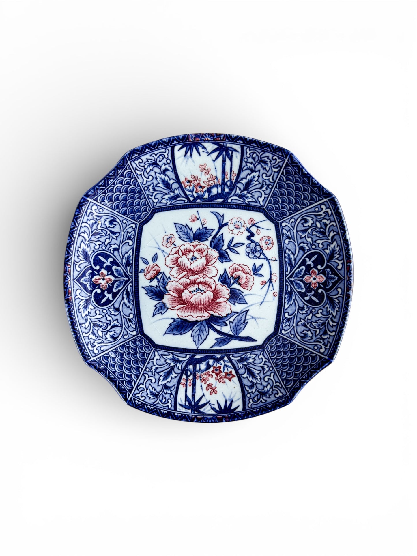 Octagonal porcelain plate with blue and red floral patterns and intricate oriental designs