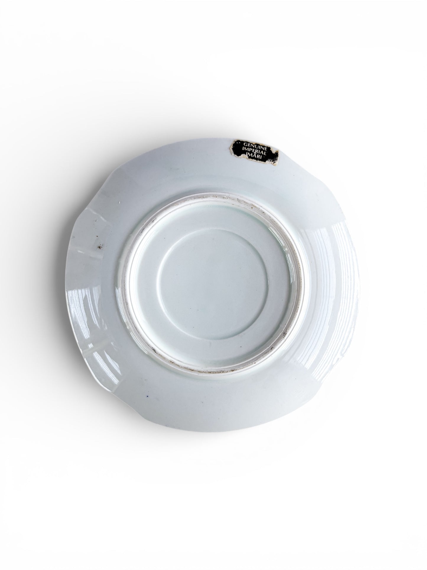 Back view of white Genuine Imperial Imari porcelain saucer with scalloped edges and minor wear