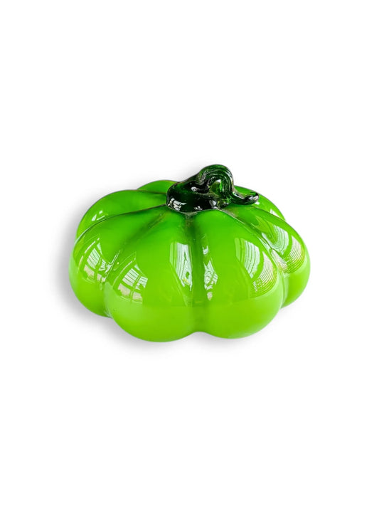 Glossy green glass pumpkin decoration with a dark green stem on white background